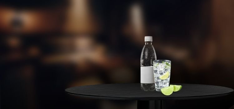 Sparkling water on a glass and bottle with lime